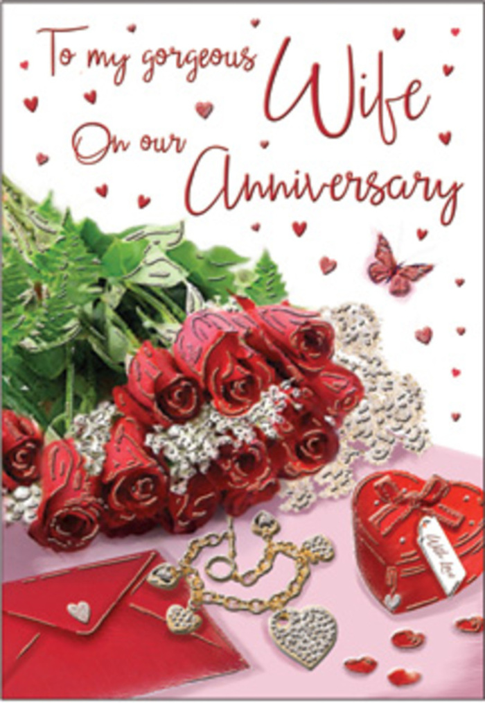 The image presents a warmly lit anniversary card arrangement that feels as if it could be sitting on a windowsill overlooking the rooftops of Guildford, bathed in calm afternoon light. At its heart is a compact bouquet of classic red roses, their rich, velvety petals spiralling outward in full, confident blooms that speak of a love well-rooted and long-nurtured. The roses are cushioned by fresh greenery, each leaf catching subtle highlights that lend depth and a natural, garden-like charm, reminiscent of a peaceful walk through Guildford Castle grounds in late summer. Just to the side, an envelope rests invitingly, its edges crisp against the softer textures around it, hinting at a handwritten note or thoughtful anniversary message still to be discovered. A delicate heart-shaped box and a refined piece of jewellery are tucked close to the flowers, their surfaces gleaming with quiet luxury, as though chosen for a milestone celebration and laid out in anticipation on a dressing table. Scattered across the scene are tiny red hearts, their playful shapes leading the eye towards a single butterfly, gently poised as if about to take flight, adding a touch of light-hearted joy to the romantic mood. Flowing script on the card curves gracefully between these elements, balancing the composition and anchoring it in personal sentiment. The atmosphere is intimate and reflective: you can almost sense the soft rustle of paper, the faint fragrance of freshly cut roses, and the cool weight of jewellery in the palm of a hand. It feels like an anniversary moment grounded in everyday life in Guildford, made special through thoughtful details and a florist's eye for harmony.